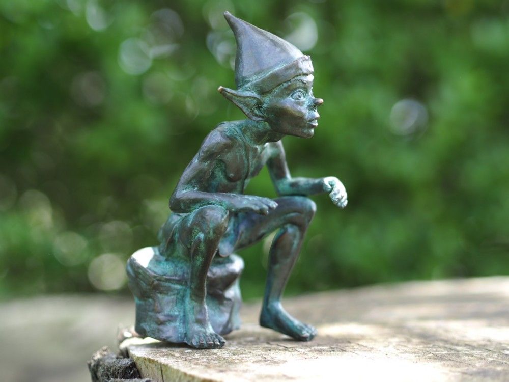 -Bronzefigur Pixi sitzend auf Stein-