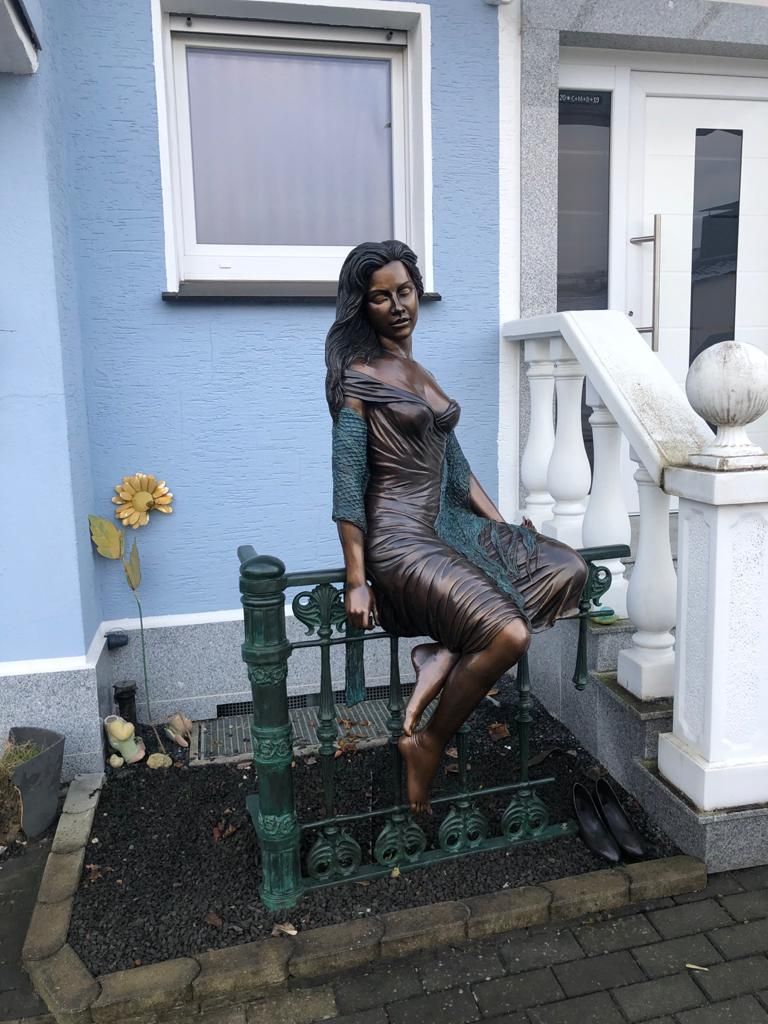 Bronzefigur Frau Sitzend auf Zaun